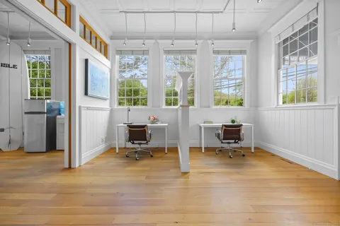 a view of a workspace with furniture and a window