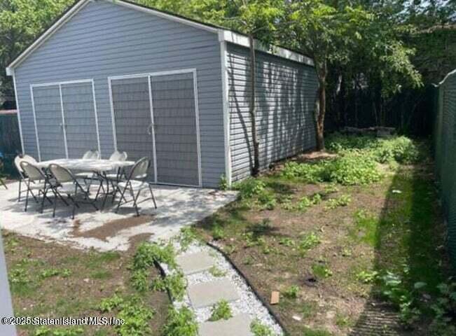 173 Clove Road Staten Island, NY 10310 - Photo 11 of 11 a view of a patio with table and chairs with wooden fence