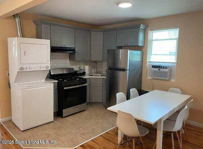 173 Clove Road Staten Island, NY 10310 - Photo 7 of 11 a kitchen with a stove a refrigerator and a table