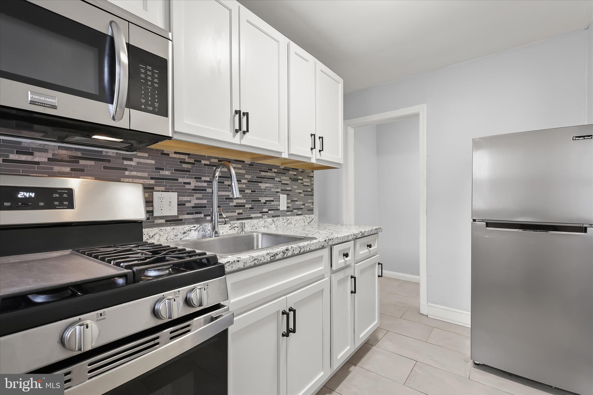 4352 Eldone Road Baltimore, MD 21229 - Photo 12 of 27 a kitchen with stainless steel appliances granite countertop a stove and a microwave