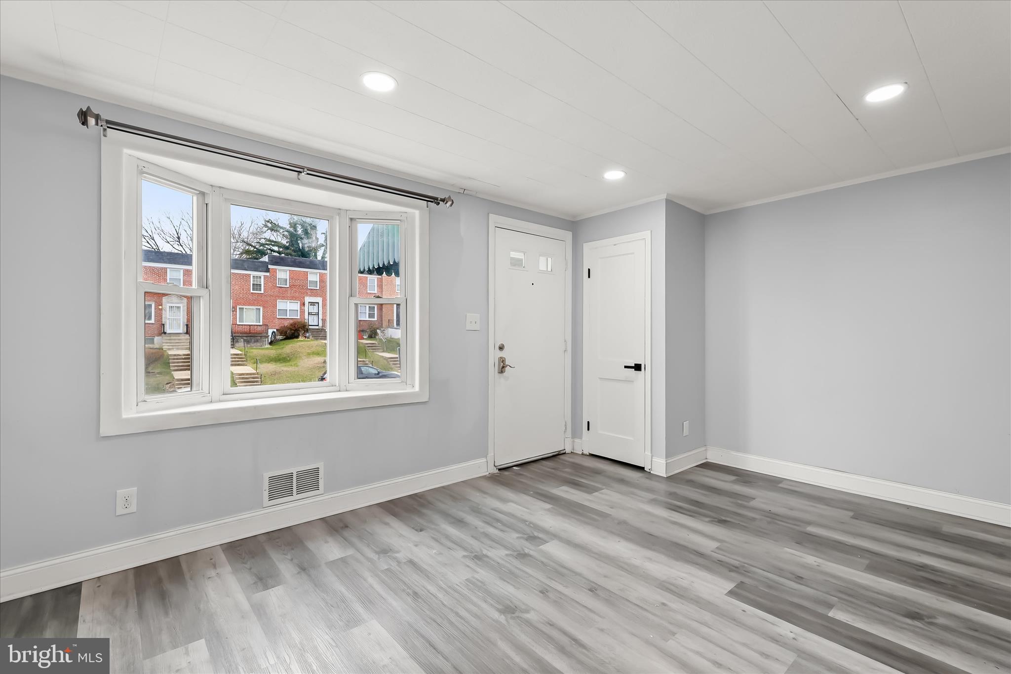 4352 Eldone Road Baltimore, MD 21229 - Photo 4 of 27 a view of an empty room with a window and wooden floor