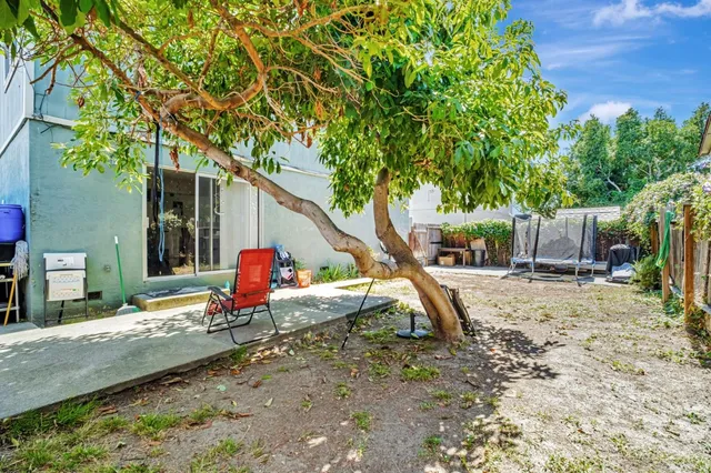 a backyard of a house with barbeque oven table and chairs