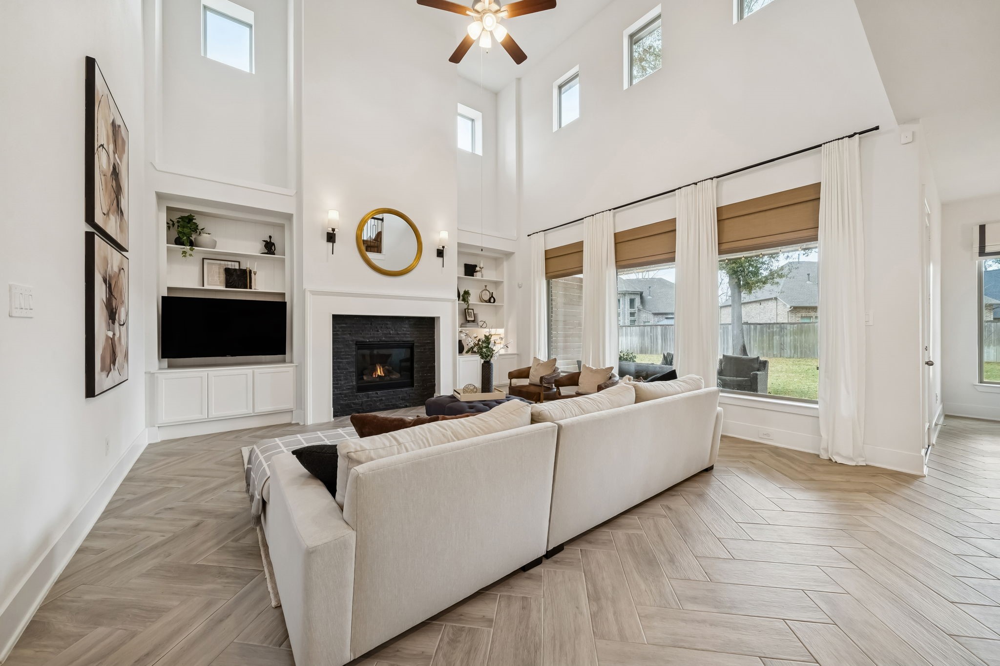 519 Caverna Street Montgomery, TX 77316 - Photo 9 of 41 The light-filled living room showcases soaring ceilings, a striking fireplace with custom built-ins, and wood-look tile flooring that carries throughout the main living areas.