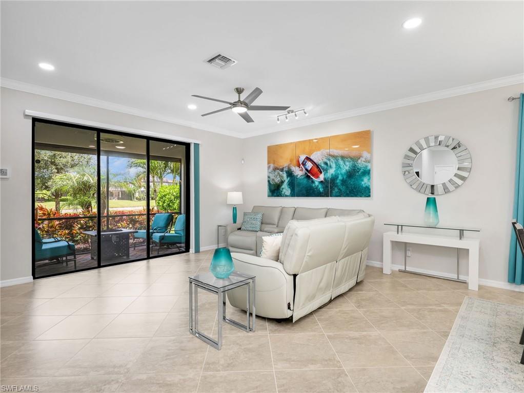 4383 Bismark Way Naples, FL 34119 - Photo 10 of 49 Living Room with Sliders Leading to the Screened In Lanai with Lake View and Paver Lanai