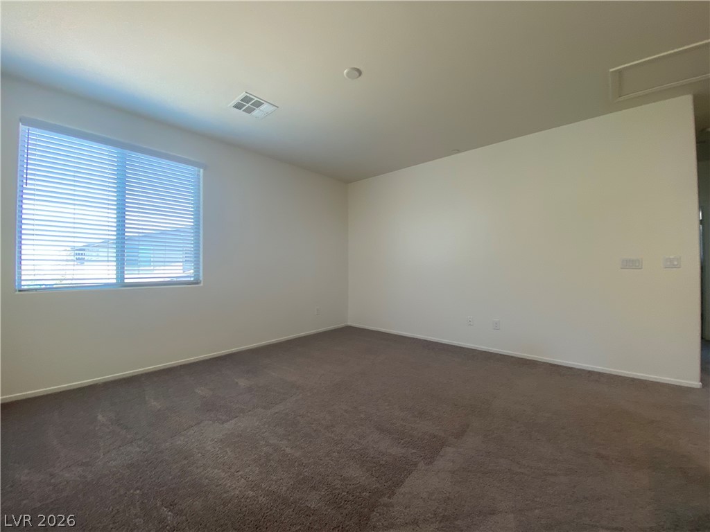 436 Cadence View Way Henderson, NV 89011 - Photo 13 of 36 A well-lit room awaits your personal touch with soft carpeting and ample natural light from the window.