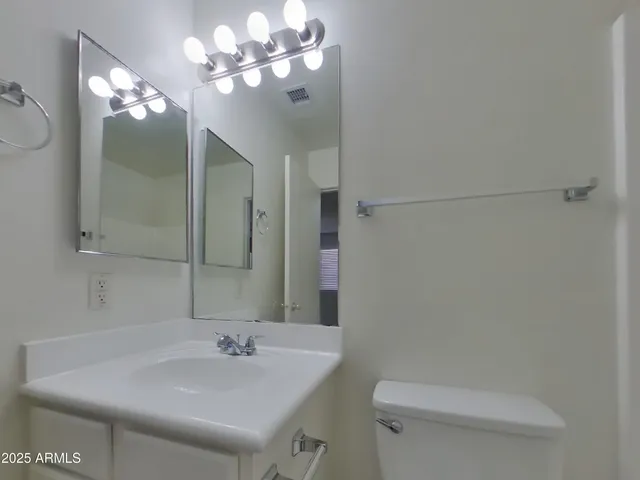 a bathroom with a sink a toilet and a mirror