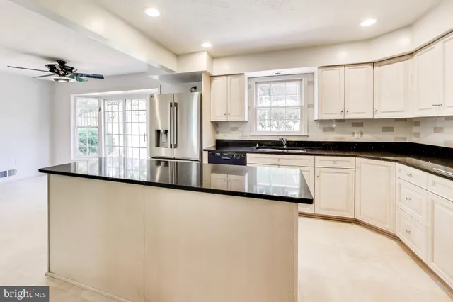 a kitchen with granite countertop white cabinets and white appliances