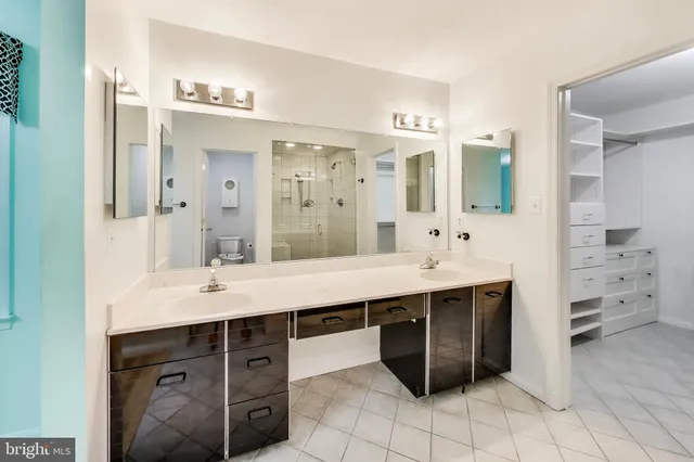 a spacious bathroom with a double vanity sink mirror and bathtub