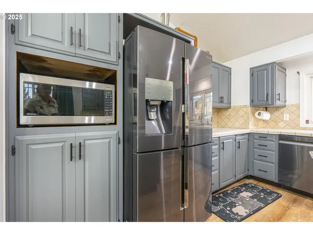a kitchen with granite countertop a sink stainless steel appliances and cabinets