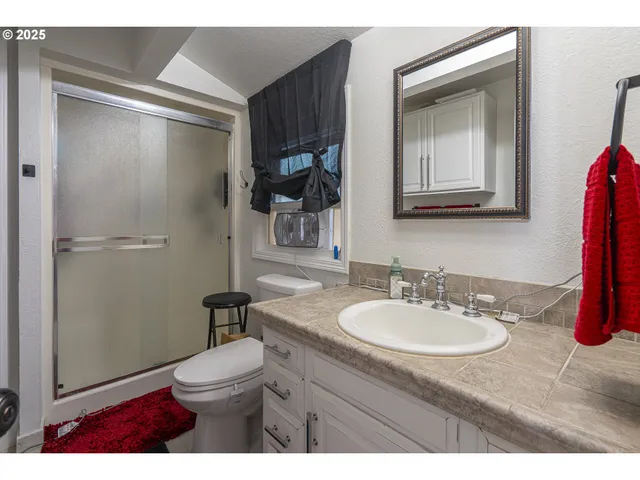 a utility room with stainless steel appliances wooden floor a rug and a couch