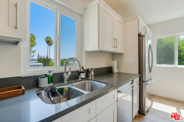 a kitchen with sink cabinets and a window