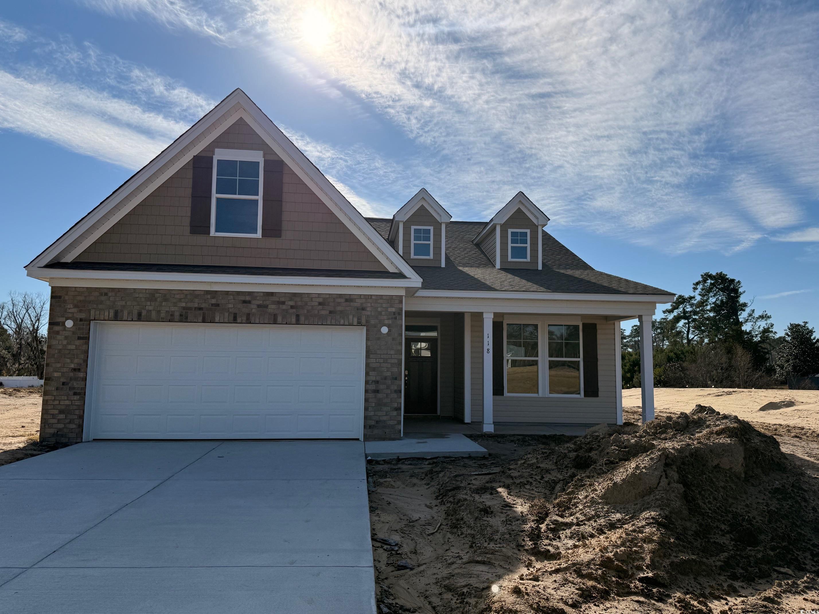 118 Cascade Drive Conway, SC 29527 - Photo 1 of 15 View of front of property featuring covered porch, concrete driveway, a garage, brick siding, and roof with shingles