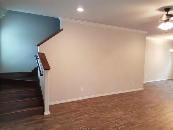 a view of a room with wooden floor and a kitchen