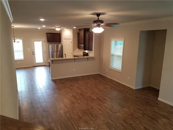 a view of a hallway with wooden floor and entryway