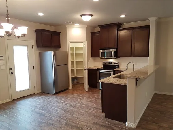 a kitchen with stainless steel appliances granite countertop a refrigerator stove a sink and a microwave