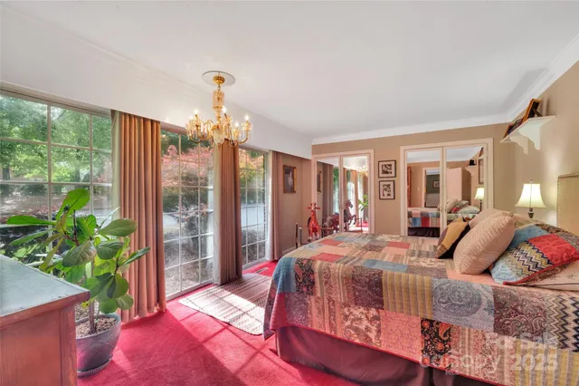 a bedroom with a bed bookshelf and a large window