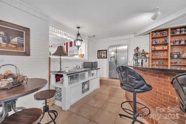 a kitchen with stainless steel appliances a stove a table and chairs in it