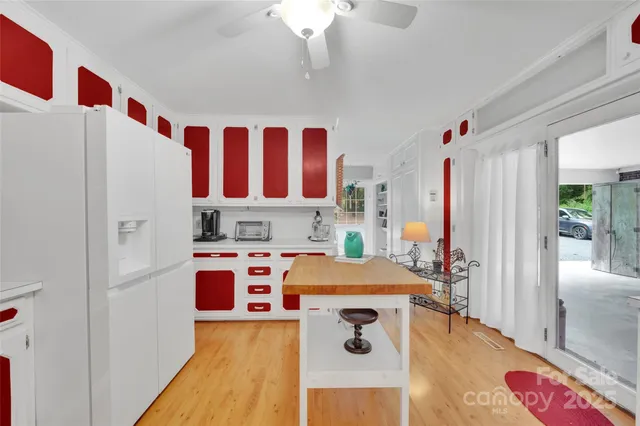 a kitchen with stainless steel appliances granite countertop a refrigerator a stove a sink and white countertops with wooden floor