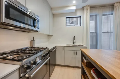 a kitchen with stainless steel appliances a sink stove and cabinets