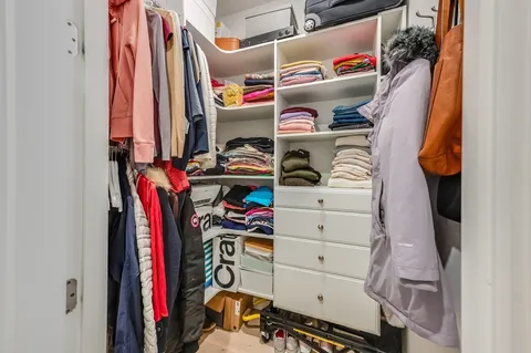 a view of walk in closet with clothes