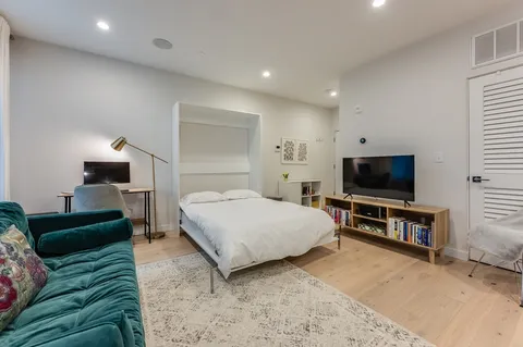 a bedroom with a bed and a flat screen television