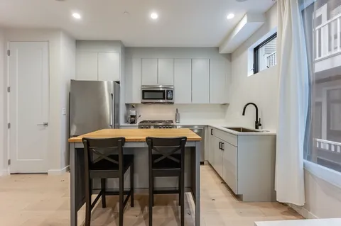 a kitchen with stainless steel appliances a sink stove and refrigerator