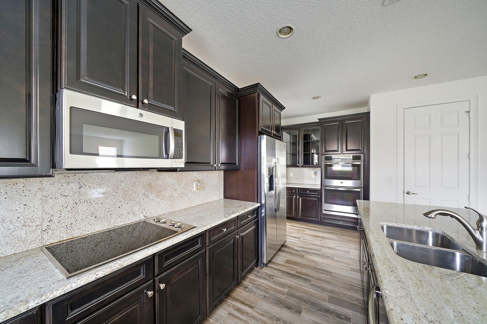 434 Rudder Cay Way Jupiter, FL 33458 - Photo 11 of 52 a kitchen with stainless steel appliances granite countertop a sink stove and cabinets