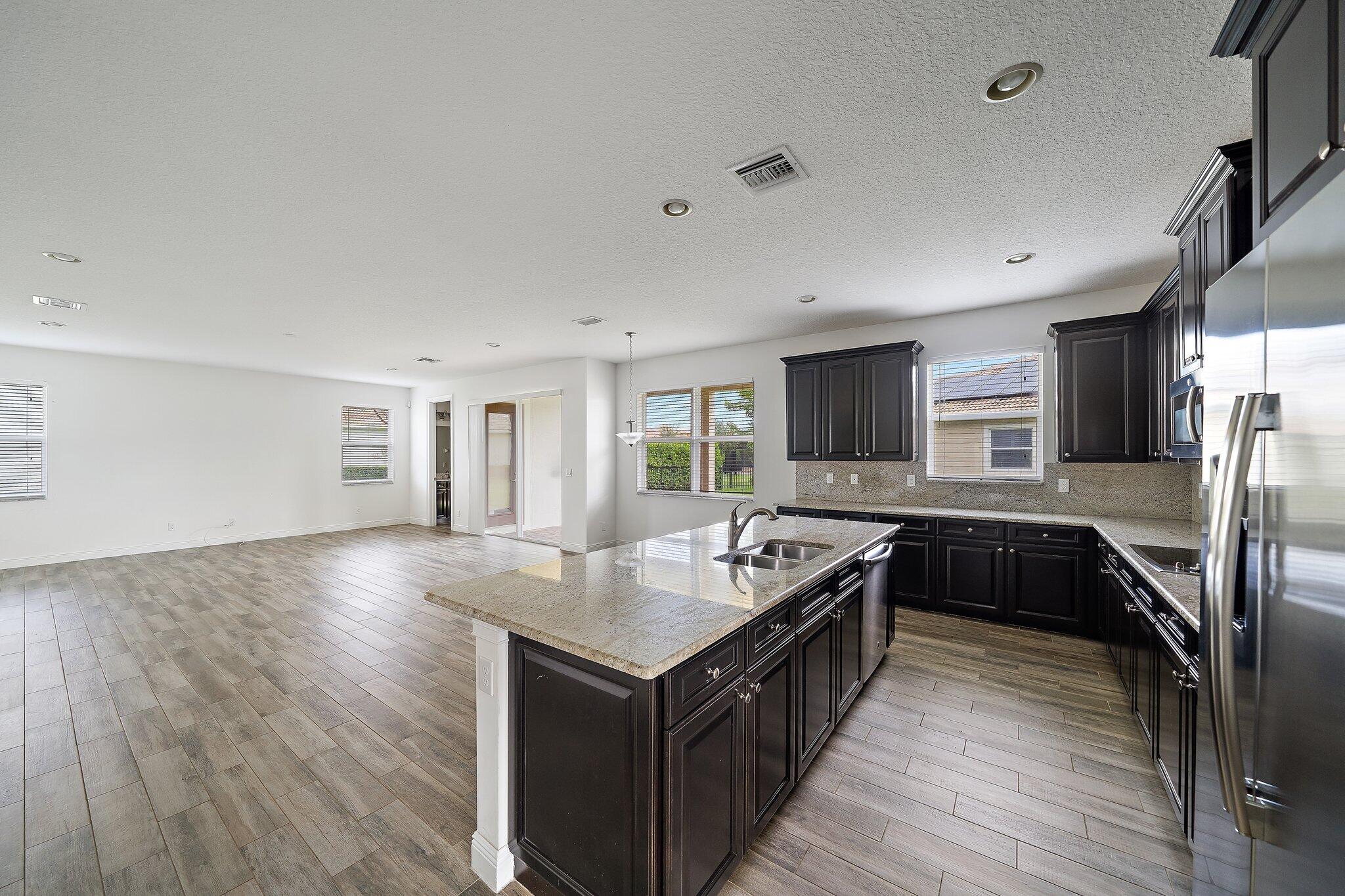 434 Rudder Cay Way Jupiter, FL 33458 - Photo 14 of 52 a kitchen with granite countertop a stove top oven and refrigerator