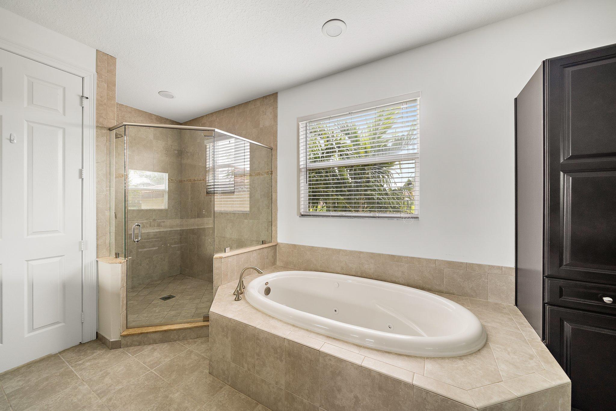 434 Rudder Cay Way Jupiter, FL 33458 - Photo 34 of 52 a bathroom with a bathtub and a shower