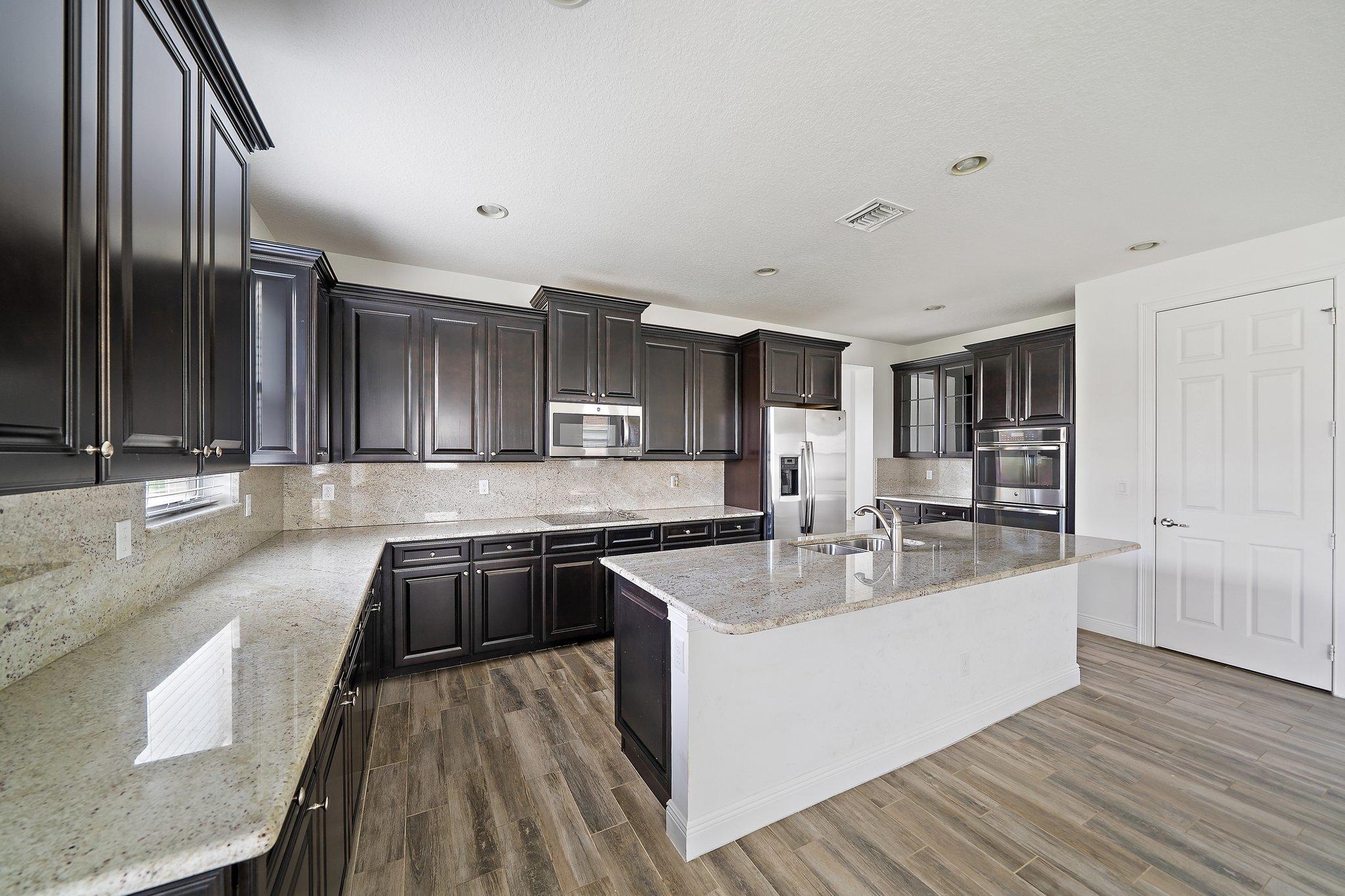 434 Rudder Cay Way Jupiter, FL 33458 - Photo 10 of 52 a large kitchen with stainless steel appliances granite countertop a lot of counter space and wooden floor