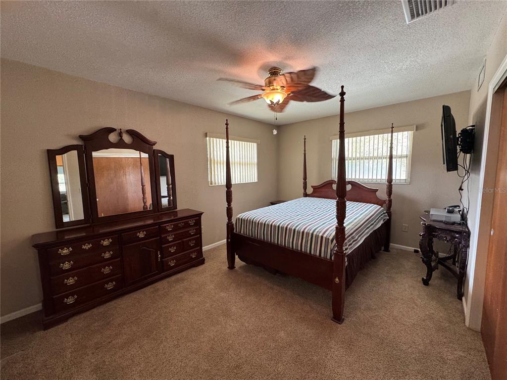 5333 Deeson Road Lakeland, FL 33810 - Photo 21 of 44 a bedroom with a bed a dresser and a flat screen tv