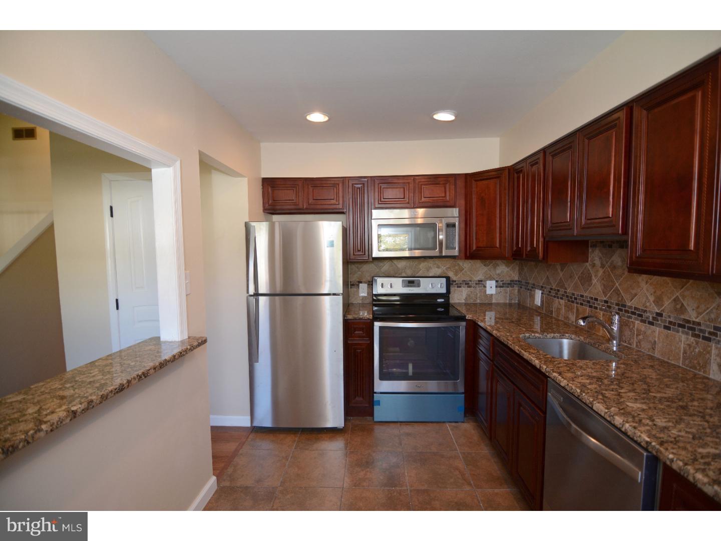 25 Merion Road Newark, DE 19713 - Photo 9 of 23 a kitchen with kitchen island granite countertop wooden cabinets stainless steel appliances and a sink