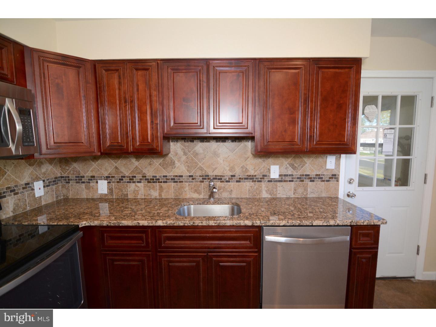 25 Merion Road Newark, DE 19713 - Photo 10 of 23 a kitchen with granite countertop wooden cabinets a sink and dishwasher