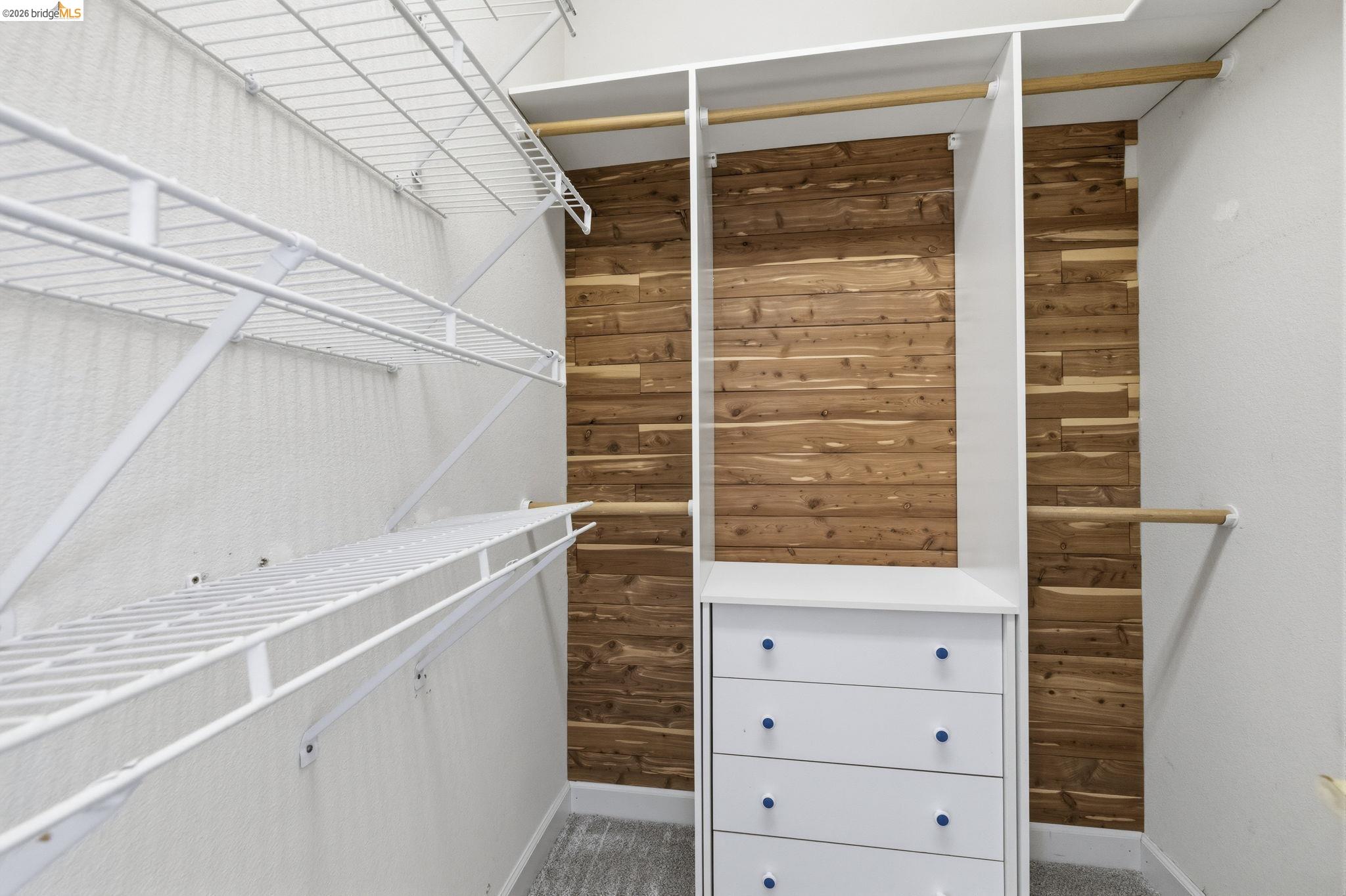 6242 Bluff View Road Copperopolis, CA 95228 - Photo 35 of 59 Custom closet featuring cedar plank wall, white wire shelving, white built-in cabinetry with drawers, and wooden hanging rods