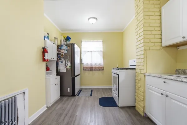 a view of a kitchen with refrigerator and wooden floor