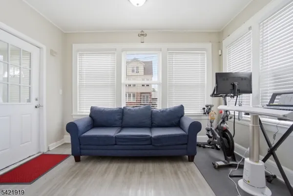 a living room with furniture a ceiling fan a window and a flat screen tv