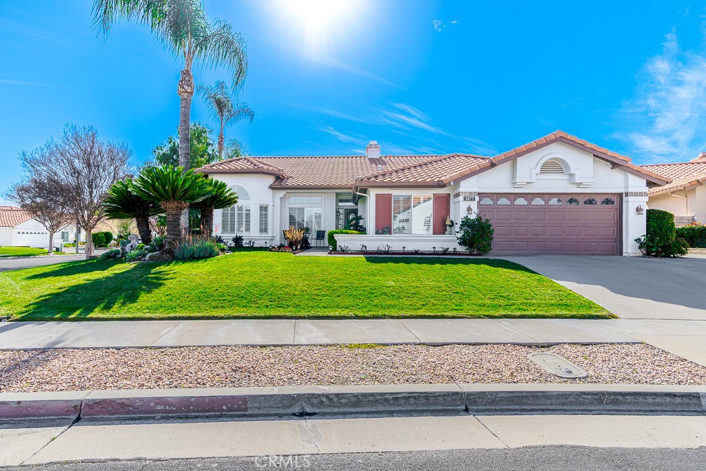 a front view of a house with a garden and yard