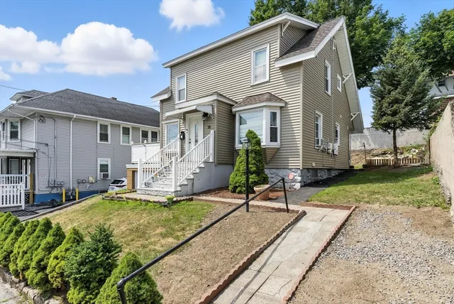 a view of a house with backyard and sitting area