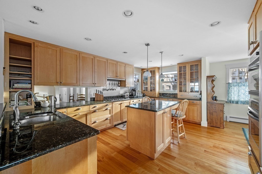 8 R Naugus Avenue Marblehead, MA 01945 - Photo 18 of 41 a kitchen with stainless steel appliances granite countertop a stove top oven a sink dishwasher a dining table and chairs with wooden floor