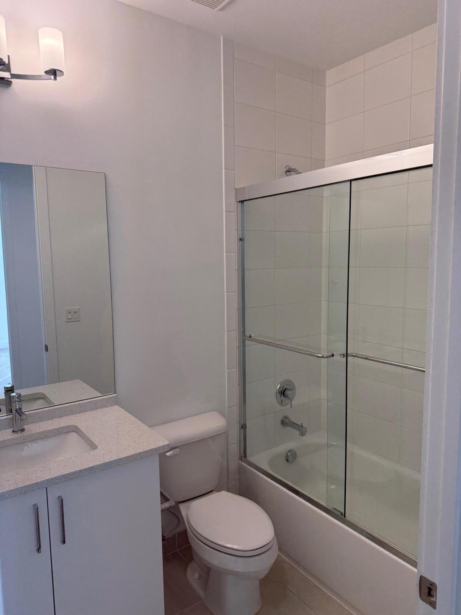 8055 White Wave Terrace Boca Raton, FL 33496 - Photo 14 of 20 a bathroom with a shower a toilet and sink