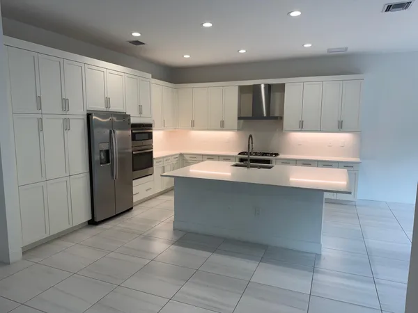 a kitchen with stainless steel appliances granite countertop a refrigerator and a stove