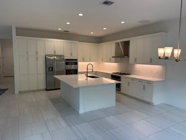 a kitchen with stainless steel appliances a refrigerator and a stove top oven
