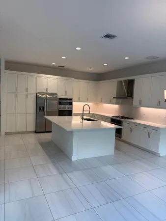 a large kitchen with a large counter top stainless steel appliances and cabinets