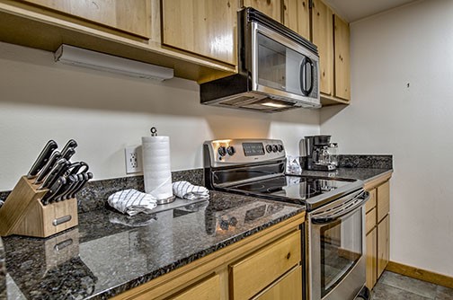 22340 Highway 6, Unit 1785 Keystone, CO 80435 - Photo 11 of 28 a kitchen with stainless steel appliances granite countertop a stove and cabinets