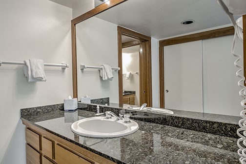 22340 Highway 6, Unit 1785 Keystone, CO 80435 - Photo 15 of 28 a bathroom with a granite countertop sink and a mirror