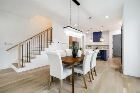 a dining room with furniture a chandelier and wooden floor