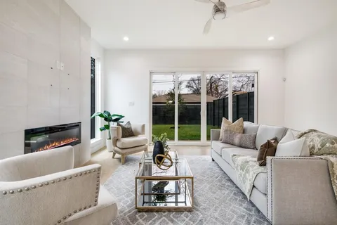 a living room with furniture large windows and a fireplace