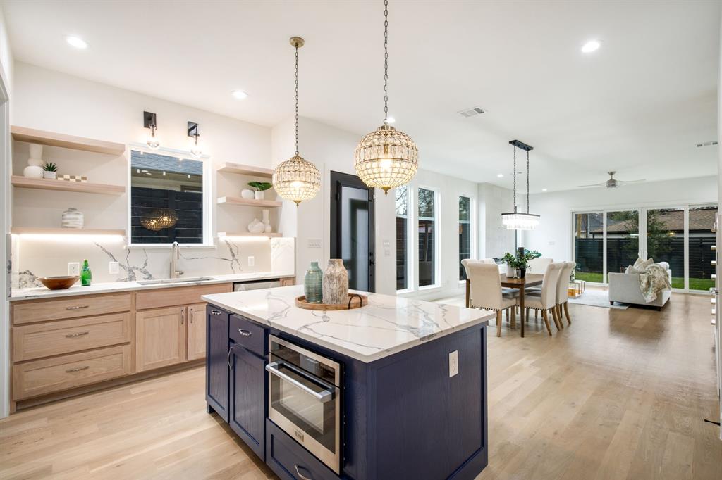 807 South Glasgow Drive Dallas, TX 75223 - Photo 13 of 39 a kitchen with stainless steel appliances granite countertop a stove a sink a oven and a view of living room