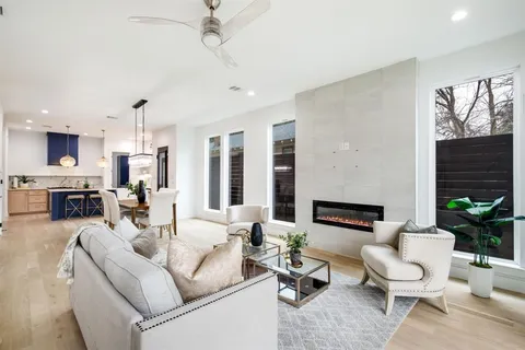 a living room with furniture a fireplace and a chandelier