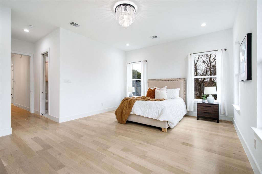 807 South Glasgow Drive Dallas, TX 75223 - Photo 28 of 39 a bedroom with a large bed and a chandelier